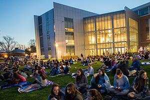 Students sitting outside on campus at night